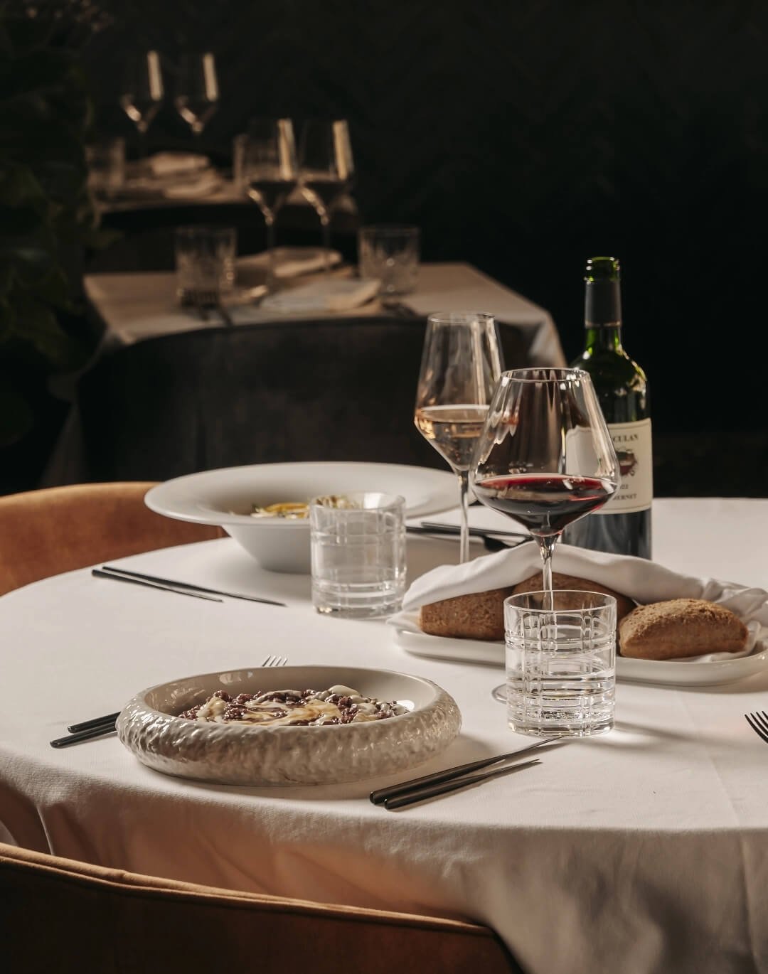 Tavolo elegante con vino rosso e risotto all&rsquo;Amarone al ristorante I Morosetti Verona